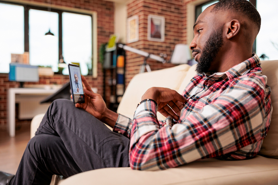 black man on cell phone for a Telehealth appointment while receiving substance abuse and mental health treatment